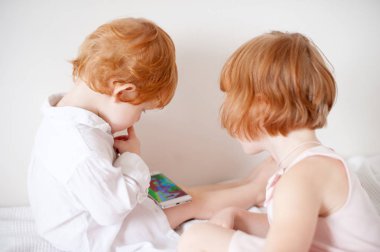 Kızıl saçlı çocuk çizgi telefonda film izlemek