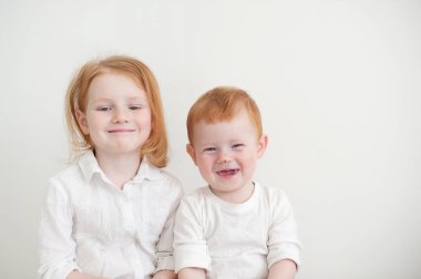 Bir kız ve bir erkek giysileri beyaz, çocuğun burun çizik