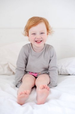 Çürük gülümsüyor beyaz yatakta bir kızla