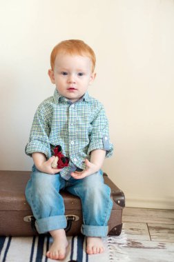 Tişört ve kot çocukta bavula oturur