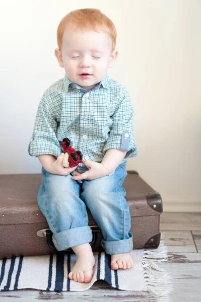 Der Junge Sitzt Mit Geschlossenen Augen Auf Einem Koffer — Stockfoto