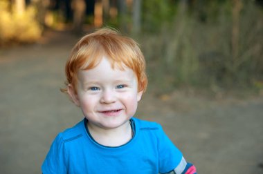 Ormanın içinde neşeli Kızıl saçlı bebek