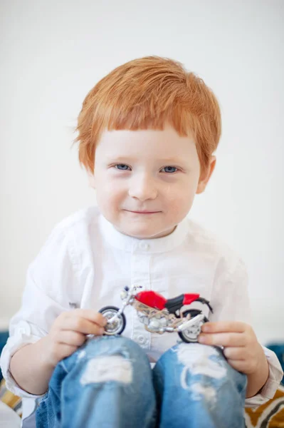 Engraçado Menino Ruivo Uma Camisa Branca Com Uma Motocicleta Brinquedo — Fotografia de Stock