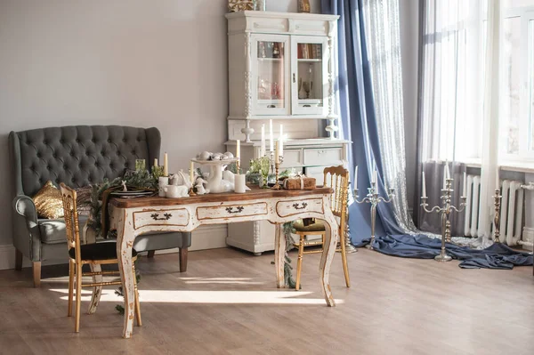 Antika masa, küçük kanepe ve şamdanlar.