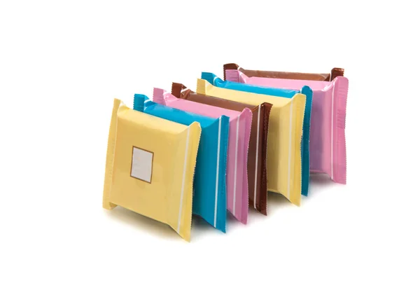 Pila de barras de chocolate en coloridos envoltorios de plástico —  Fotos de Stock