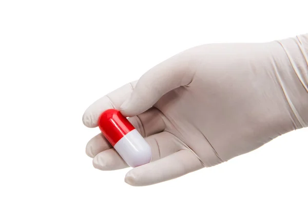 Ręka trzyma kapsułki lub tabletki w Rękawice medyczne — Zdjęcie stockowe