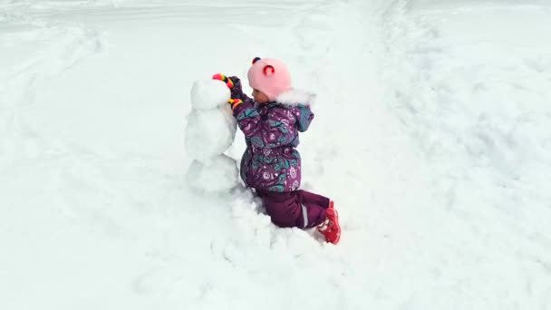 Meisje mallen sneeuwpop — Stockvideo