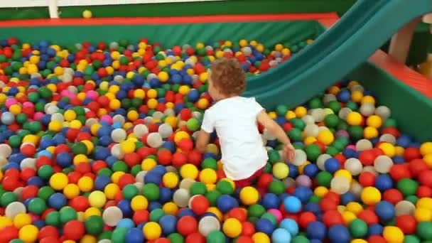 Little girl plays in the pool with spheres — Stock Video