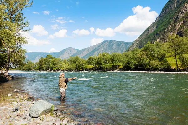 Hengelsport door flyfishing op de rivier. Rusland Siberië. Rivier Chelus — Stockfoto