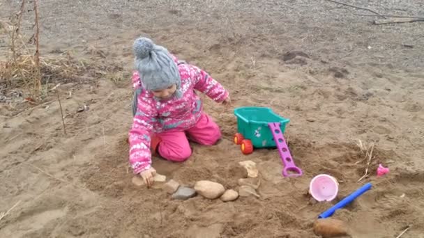 Little girl plays on coast stones — Stock Video