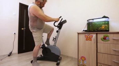 egzersiz bisikleti odasında üzerinde meşgul adam