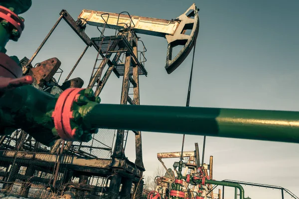 Olja pump jack och wellhead i oljefält — Stockfoto