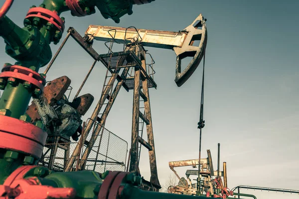 Petrol pompa jack ve geçen petrol sahası içinde — Stok fotoğraf