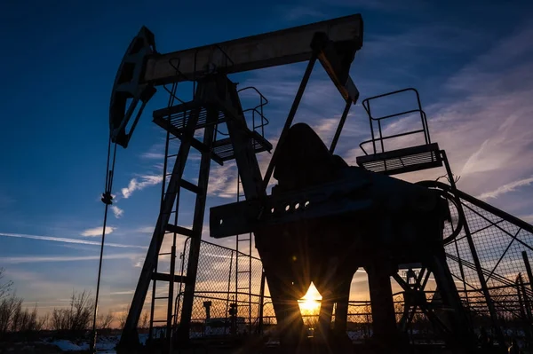 Olja pump jack på sunset himmel bakgrund . — Stockfoto