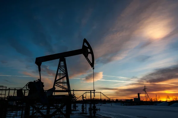 Нефтяной насос на фоне заката . — стоковое фото