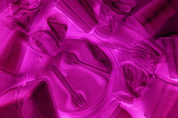 Louça de mesa de plástico descartável em cores de iluminação de néon. Minimalista ecologicamente limpo ainda vida. Pop Art. E conceito de problema ecologia . — Fotografia de Stock