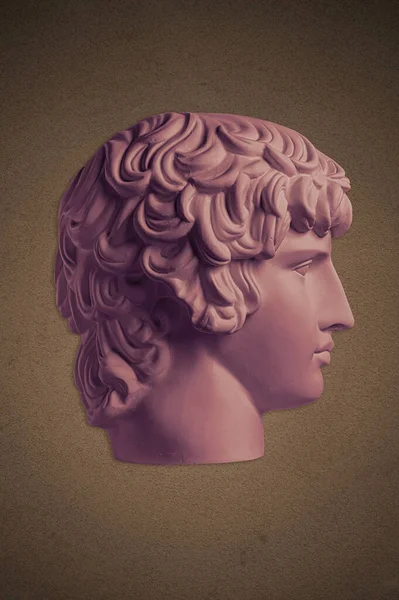 Plakát gipszmásolattal az ősi híres szoborról Antinous fej sötét textúrájú háttérrel. Gipsz antik szobor fiatal férfi arc reneszánsz kor. — Stock Fotó