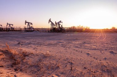 Petrol pompası. Petrol ve gaz üretimi. Petrol sahası. Pompa Jack çalışıyor. Fosil yakıt üretimi ve ham petrol üretimi için sondaj rayları. Küresel Coronavirus COVID 19 krizi. Petrol fiyatlarıyla savaş.
