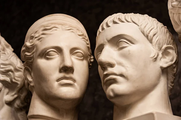 Csoportos gipsz mellszobrok ősi szobrok emberi fejek művészek sötét háttérrel. Gipsz szobrok antik emberek arcát. Reneszánsz kori stílus. Tudományos téma. Üres a kreativitáshoz. — Stock Fotó