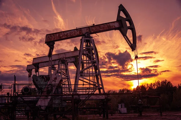 Oil pump rig. Oil and gas production. Oilfield site. Pump Jack are running. Drilling derricks for fossil fuels output and crude oil production. War on oil prices. Global coronavirus COVID 19 crisis. — Stock Photo, Image