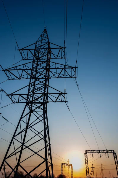 Strommast mit Drähten vor Sonnenuntergang. Sendemast. Stromleitungen an einem bunten Sonnenuntergang. Nahaufnahme Hochspannungsleitungen Silhouette. Hochspannungs-Strommast. — Stockfoto