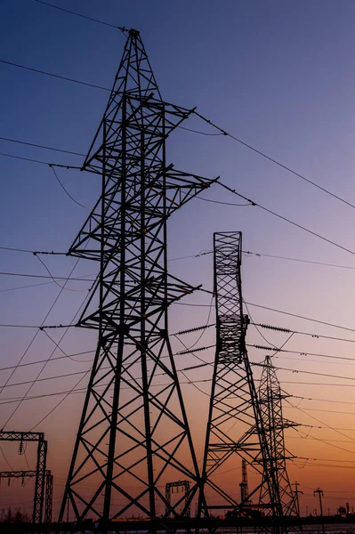 Strommast mit Drähten vor Sonnenuntergang. Sendemast. Stromleitungen an einem bunten Sonnenuntergang. Nahaufnahme Hochspannungsleitungen Silhouette. Hochspannungs-Strommast. — Stockfoto