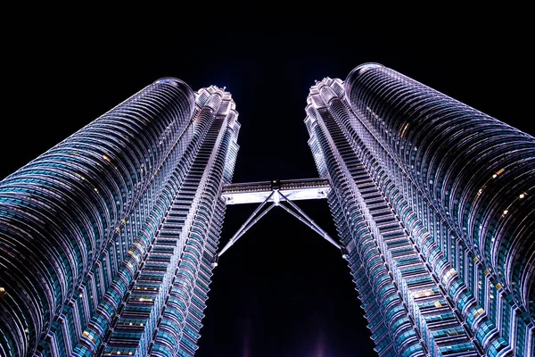 Gece Petronas İkiz Kuleleri 'ndeki güzel ışık gösterisini yerden seyret. KLCC 'deki dünyaca ünlü simgesel gökdelenler ve Malezya sembolü. Aydınlatılmış bina.