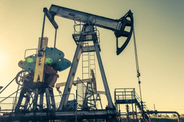 Petrol pompası. Petrol ve gaz üretimi. Petrol sahası. Pompa Jack çalışıyor. Fosil yakıt üretimi ve ham petrol üretimi için sondaj rayları. Petrol fiyatlarıyla savaş. Küresel Coronavirüs COVID 19 krizi.