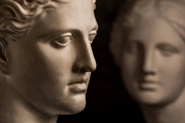 暗い背景に芸術家のための古代の彫像の人間の頭のグループ石膏の胸像 アンティークの人々の顔の石膏彫刻 ルネサンス時代のスタイル 創造性のためのブランク 学問的科目 — ストック写真