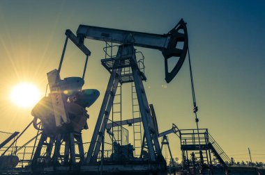 Petrol pompası. Petrol ve gaz üretimi. Petrol sahası. Pompa Jack çalışıyor. Fosil yakıt üretimi ve ham petrol üretimi için sondaj rayları. Petrol fiyatlarıyla savaş. Küresel Coronavirüs COVID 19 krizi.