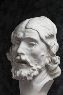 Koyu dokulu arka plan üzerinde antik heykeli John The Baptist baş Alçı kopya. Alçı heykel adam yüz.