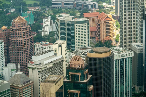 マレーシアのMenara KLタワーにあるSky Boxの透明なガラスバルコニーを通して、驚くほど印象的な都市の空中ビュー。アジアの都市の金融地区やビジネスセンター。高層建築物. — ストック写真