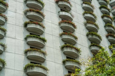 Çiçeklerle kaplı balkonların yakın plan fotoğrafı. Modern mimari, peyzaj binaları, dış yapı inşaatı, inşaat endüstrisi veya teknoloji konularında soyuttur. Balkon detayları.