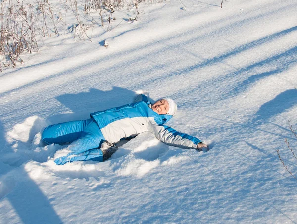 Jovem feliz em terno de esqui azul na neve — Fotografia de Stock