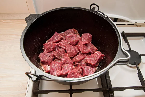Surowe mięso w żeliwnym garnku — Zdjęcie stockowe