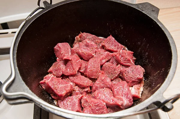 Surowe mięso w żelaznym garnku — Zdjęcie stockowe