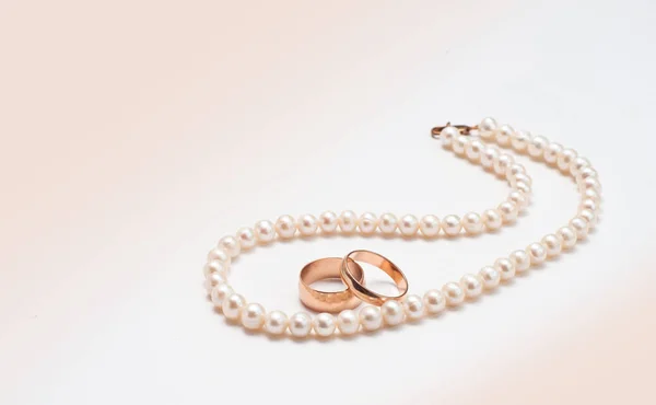 Anelli nuziali e perle bianche — Foto Stock