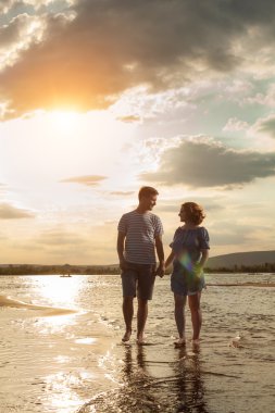 Mutlu çift sahilde yürüyor. 