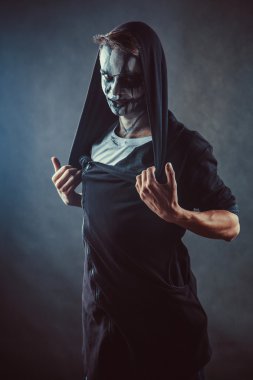 Ürkütücü yüzü ile kapüşonlu adam zombi.