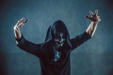 Ürkütücü yüzü ile kapüşonlu adam zombi.