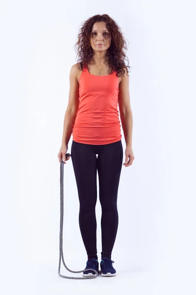 Porträtt av muskulös ung kvinna tränar med hoppa rep på vit bakgrund. — Stockfoto