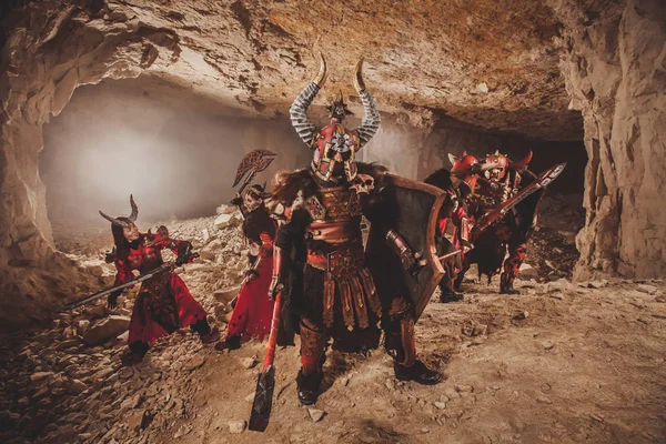 ダンジョンで重装甲で強力な騎士団の戦い。前景に斧を持つ強大な戦士. — ストック写真