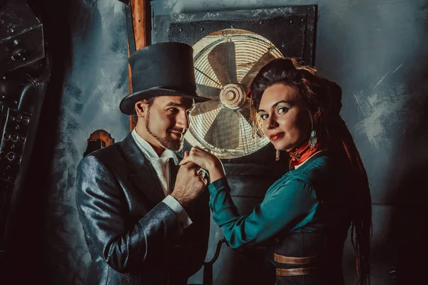 Pěkně flirtování pár oblečených v historických kostýmech na pozadí temné místnosti. — Stock fotografie