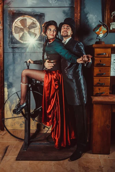 Bastante pareja coqueta vestida con trajes vintage en el fondo de la habitación oscura . —  Fotos de Stock