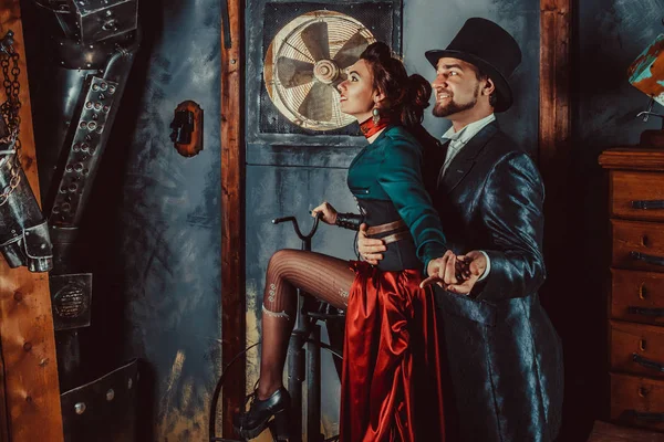 Joli couple flirtant vêtu de costumes vintage sur le fond de la pièce sombre . — Photo