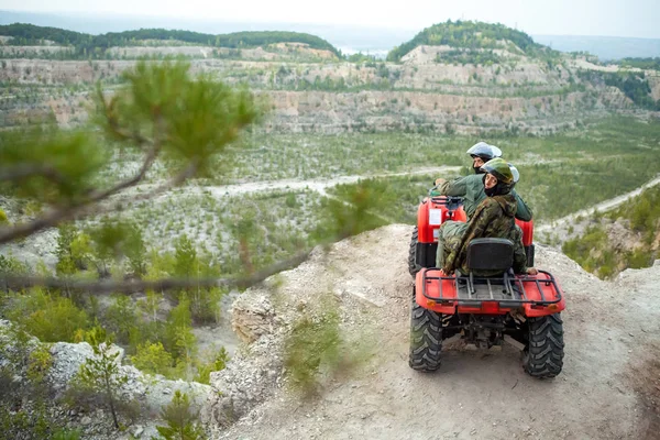 美しいカップルは、quadbike の上に座って山から夕日を見ています。. — ストック写真