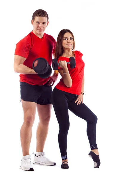 Muscular bodybuilder guy with woman doing exercises with dumbbells over white background — Stock Photo, Image