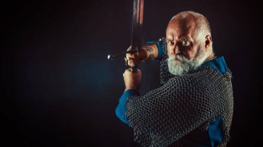 Koyu arka plan üzerinde kılıçla güçlü sakallı knight