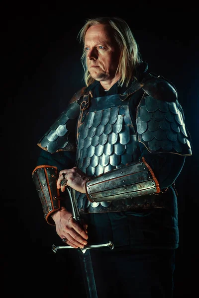 Koyu arka plan üzerinde kılıçla güçlü sarışın knight — Stok fotoğraf