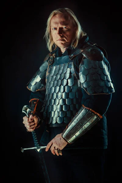 Powerful blond knight with the sword on the dark background — Stock Photo, Image